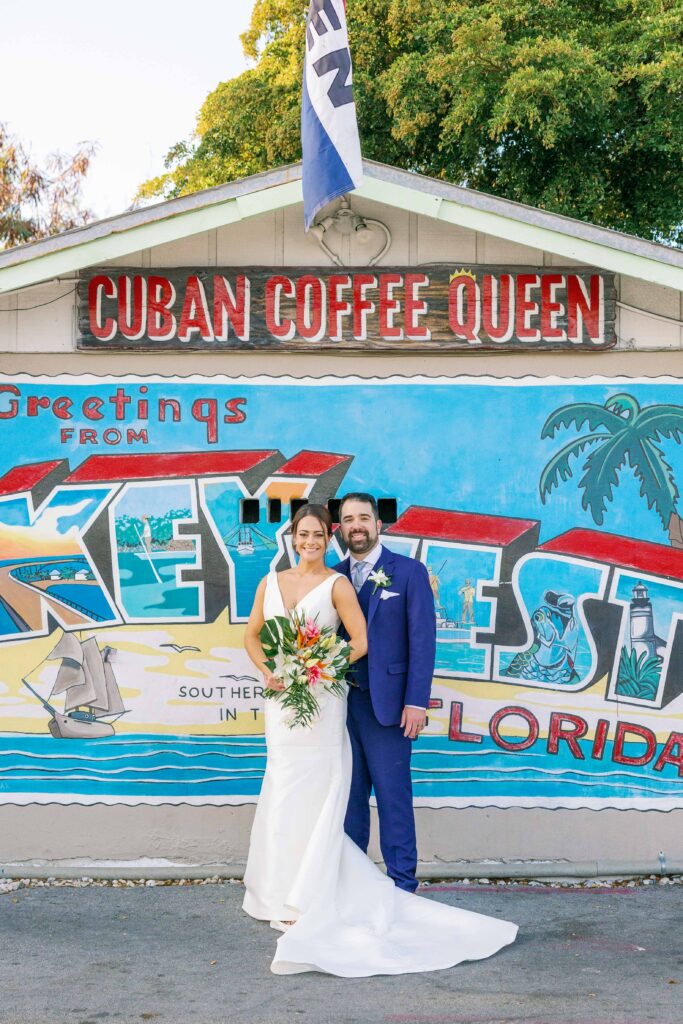 Portrait of a bride and groom in front of a painted Key West sign