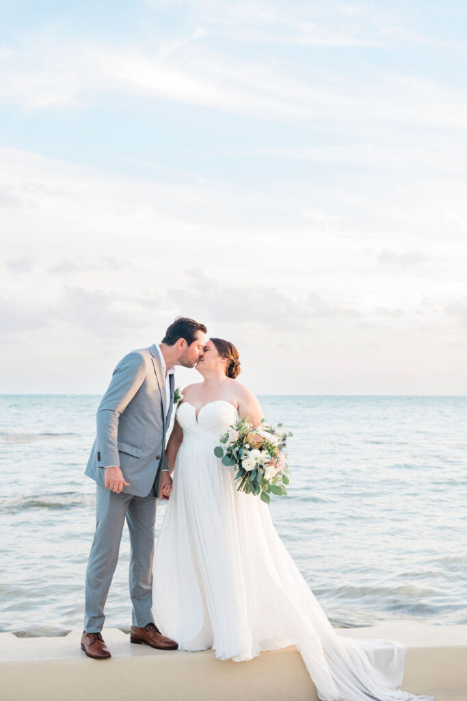 A bride and groom sharing a kiss by the water after their Key West wedding