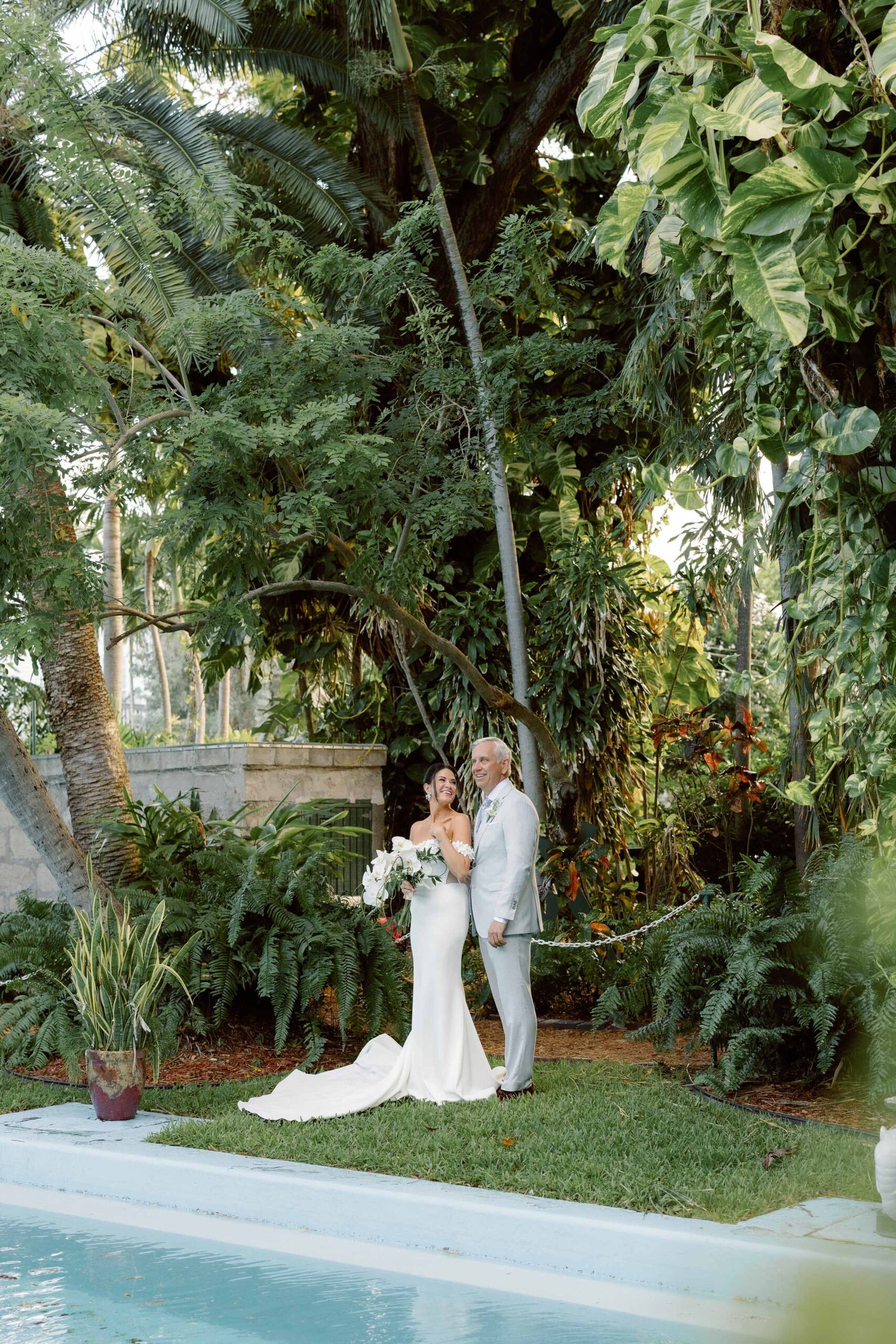 Bride and groom pose together by the pool of The Ernest Hemingway Home at their Key West wedding