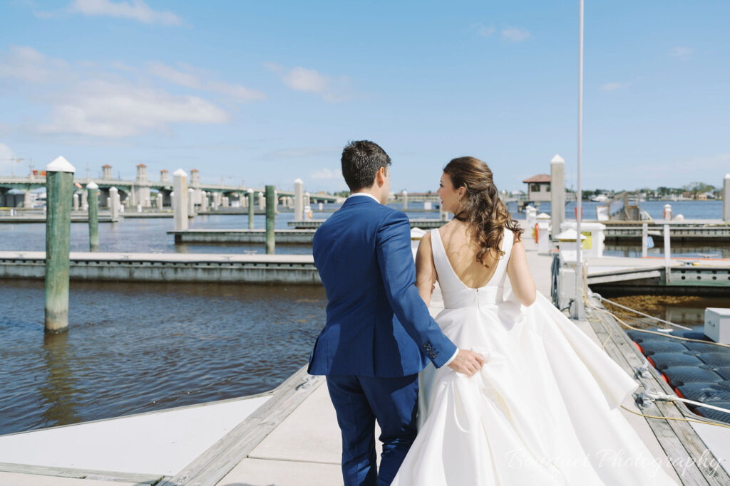 A bride and groom take photos along the water in St. Augustine.