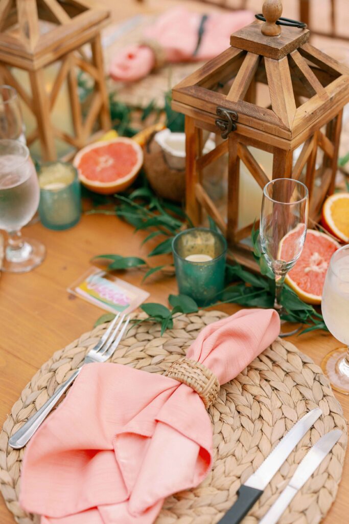 A tropical wedding tablescape with coral napkins and fruit-inspired centerpieces at a Florida Keys wedding.