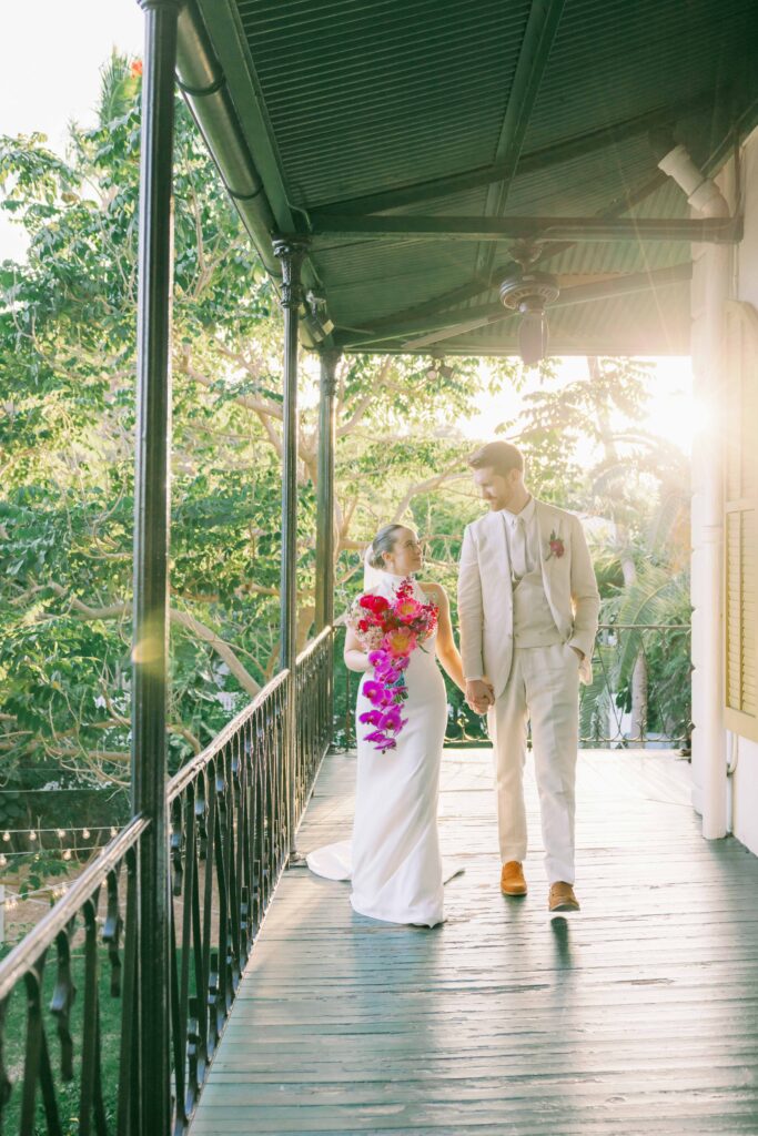 Bride and Groom at their Key West wedding. They are walking on the veranda of the Ernest Hemingway Home