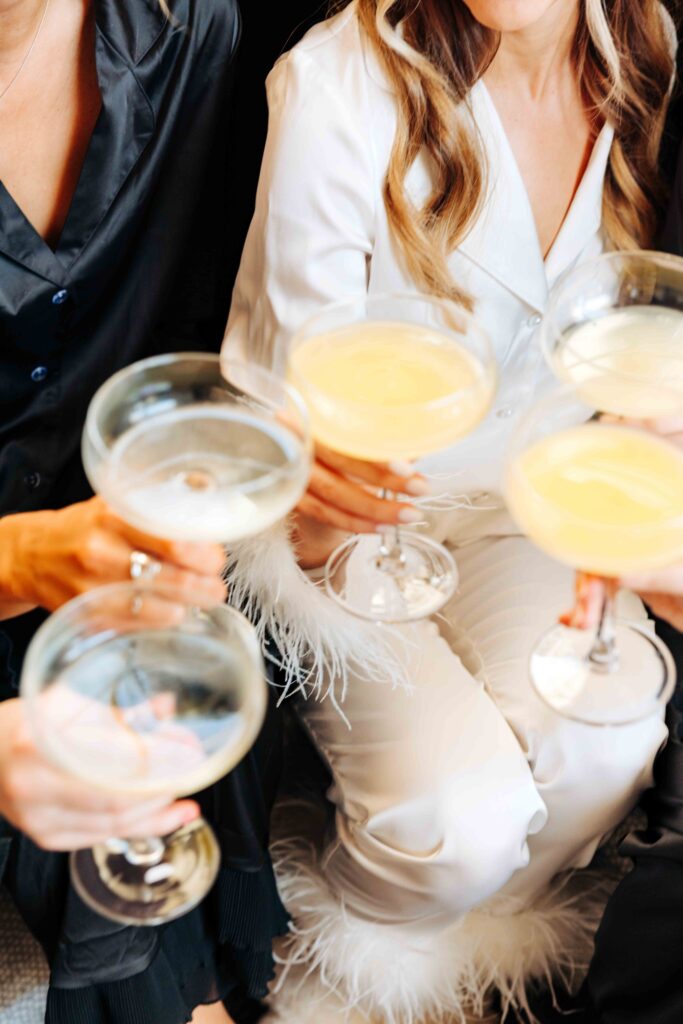 A bride and her bridesmaids cheers while getting ready for their Key West wedding.