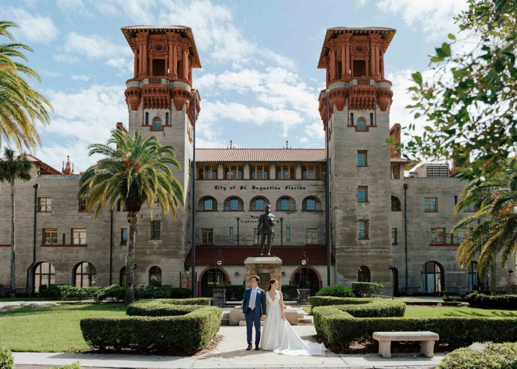 A St. Augustine wedding. The Bride and Groom stand in front of The Lightner Museum.