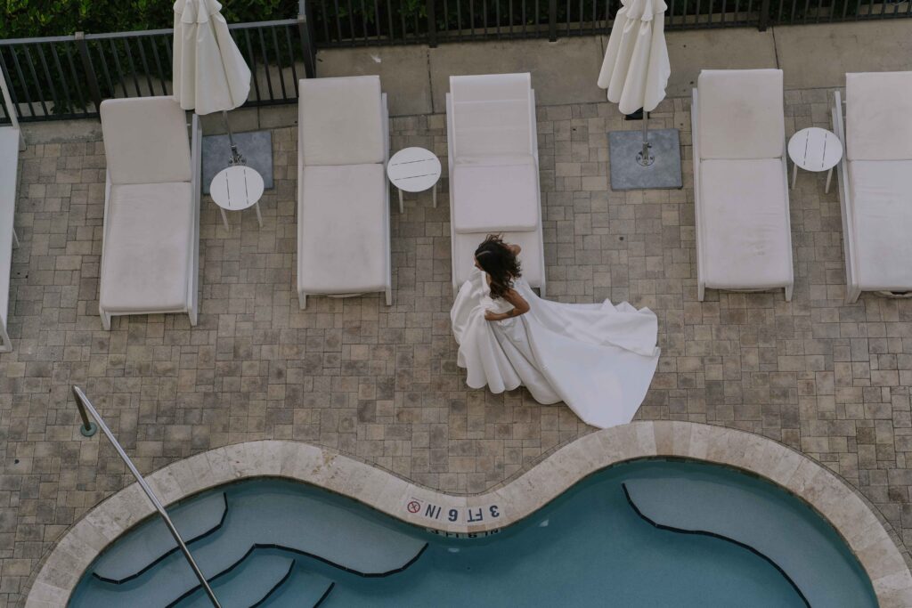 A bride walking by the pool at Hotel Zamora
