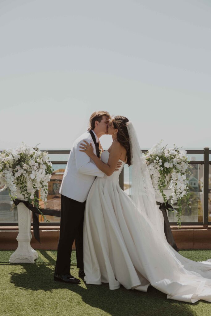 The bride and groom share their first kiss on the rooftop wedding at Hotel Zamora.