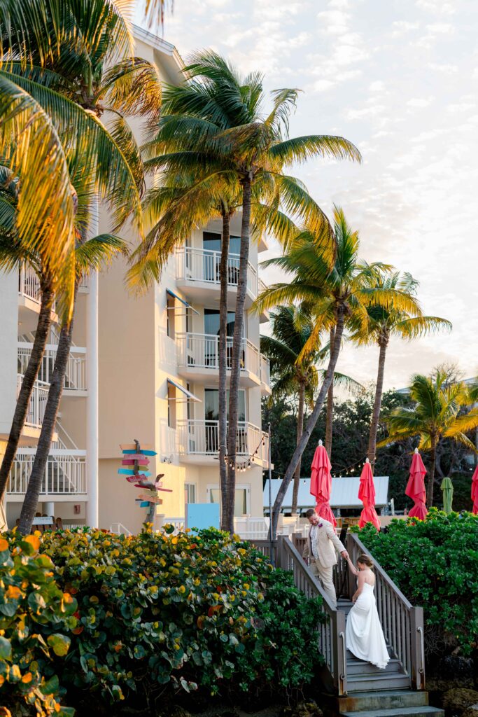 A bride and groom on the steps of Hyatt Centric in Key West at sunset